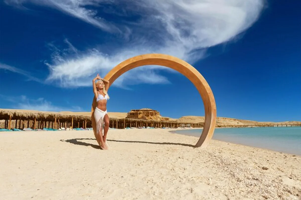 Młoda kobieta moda stojąca na plaży obok wody