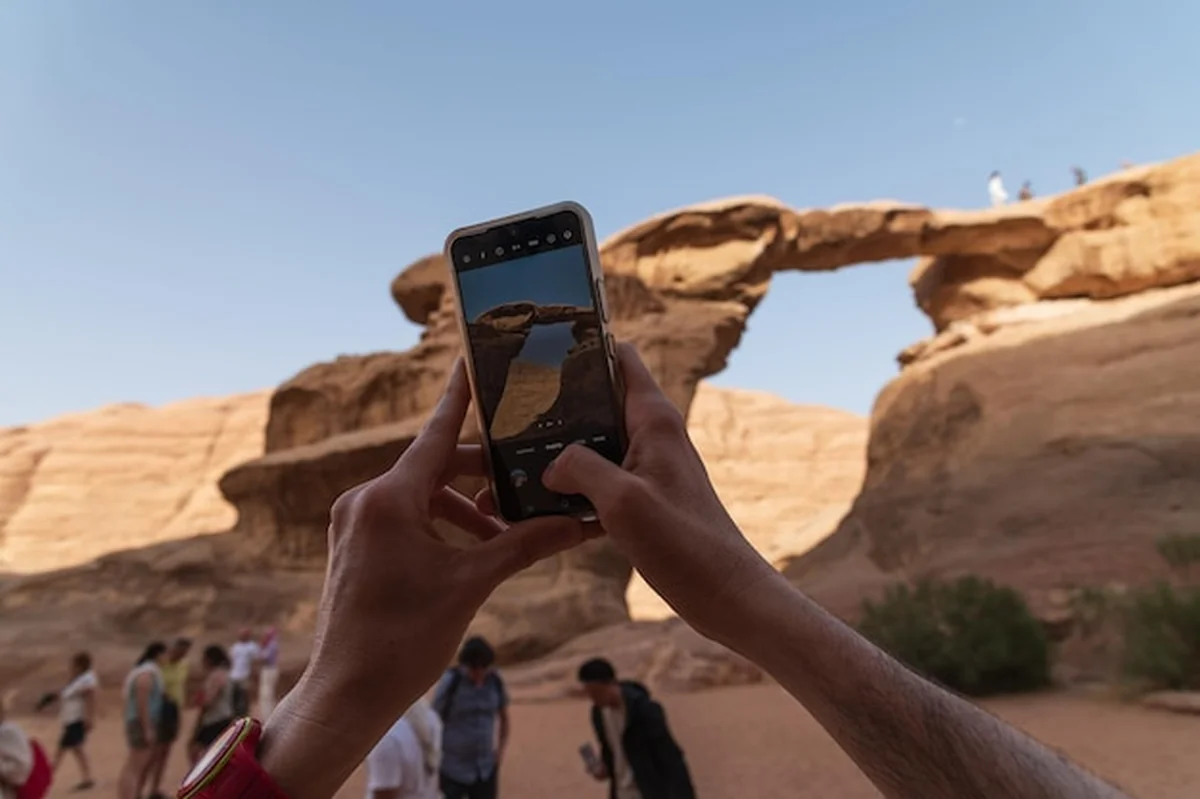 Turysta fotografuje kamienny most na pustyni Wadi Rum w Jordanii