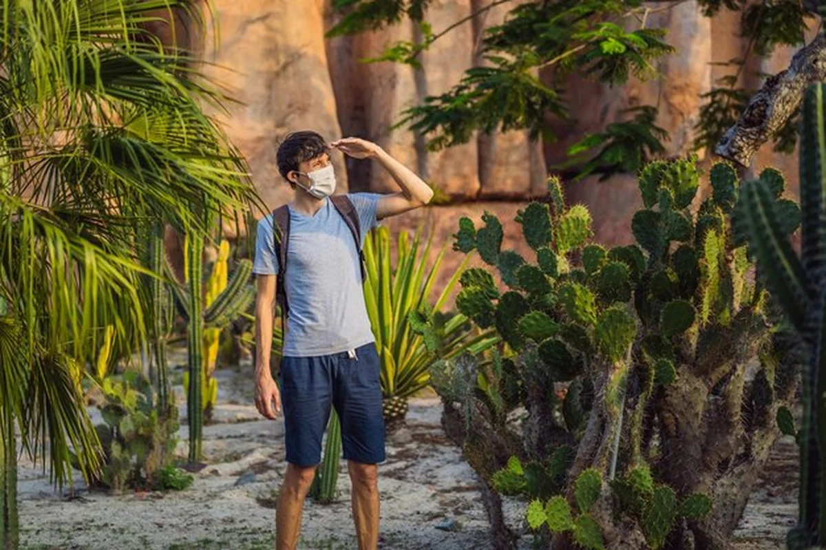 Młody podróżnik z maską medyczną na pustyni Afryki