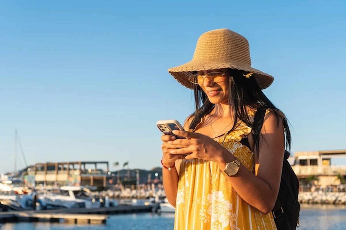 Turysta korzystający ze smartfona na przystani podczas wakacji