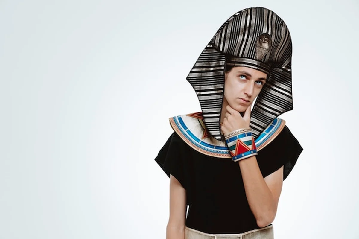 Mężczyzna w starożytnym egipskim stroju z zamyślonym wyrazem twarzy na białym tle