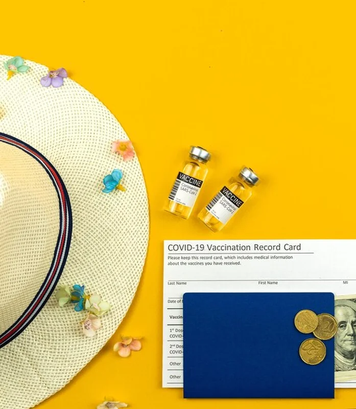 Widok z góry na fiolki ze szczepionkami i kartę szczepień podczas wakacji