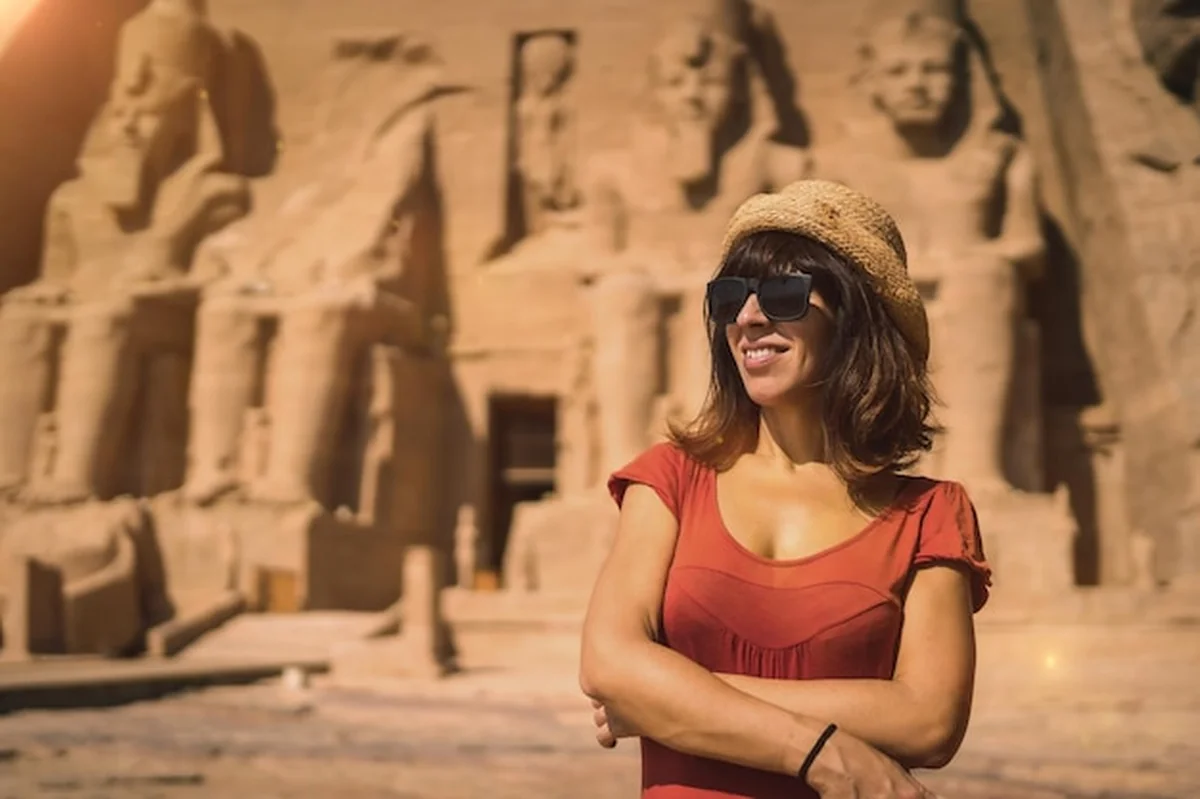 Młoda turystka w czerwonej sukience w świątyni Abu Simbel w południowym Egipcie w Nubii