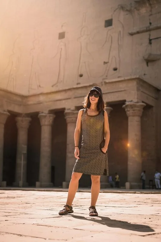 Młody turysta w czapce przy świątyni Edfu o wschodzie słońca w Asuanie, Egipt