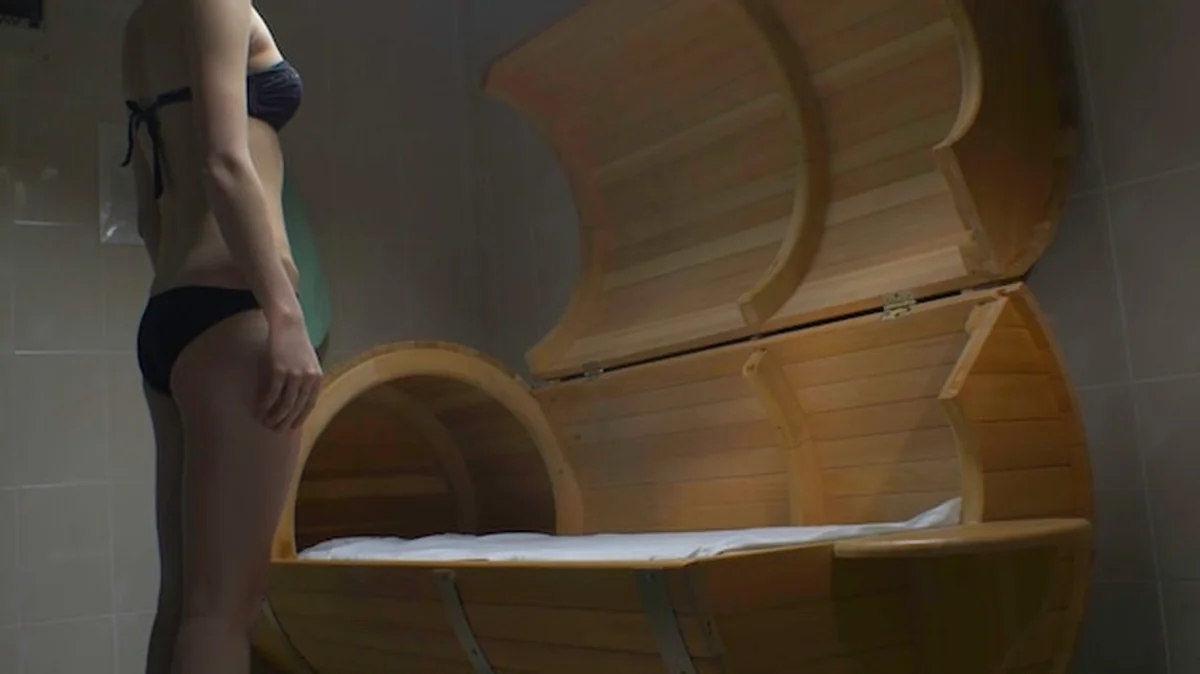 Kobieta biorąca zabiegi spa, siedząca w beczce z sosny