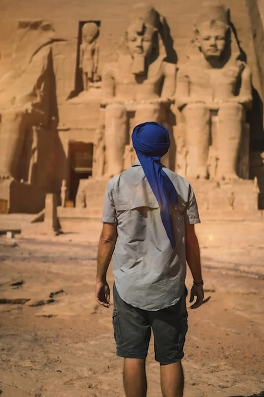Młody turysta w niebieskim turbanie przy świątyni Abu Simbel w Egipcie na południu
