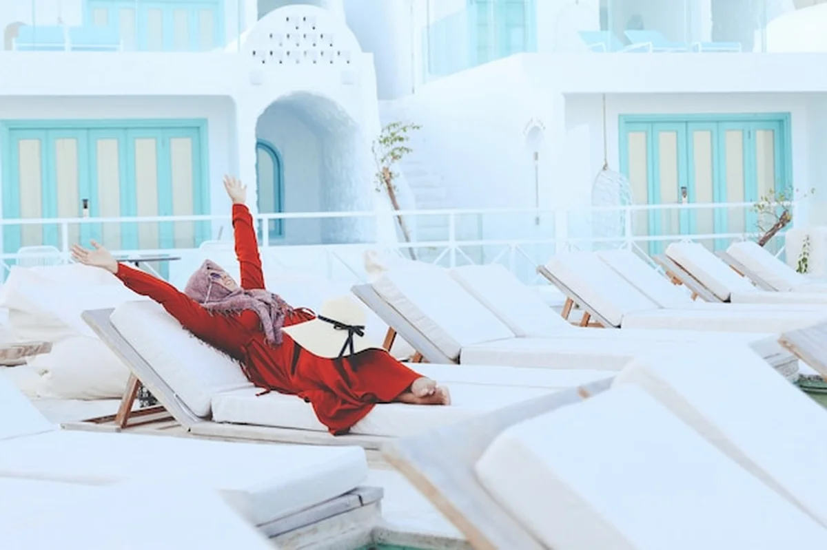 Szczęśliwa kobieta w szaliku i okularach przeciwsłonecznych na wakacjach