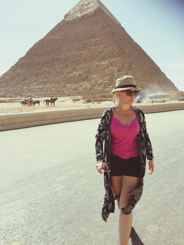 Młoda kobieta idąca po drodze w pustyni w słońcu