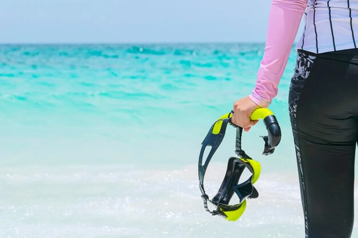 Turystki ze sprzętem do nurkowania na tropikalnej plaży