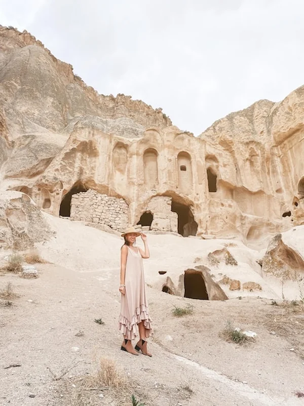 Młoda kobieta w Kapadocji przed starożytnymi formacjami jaskiniowymi