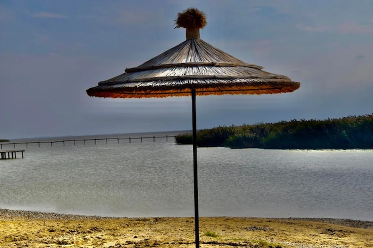 Plaża na jeziorze z parasolem i niebem