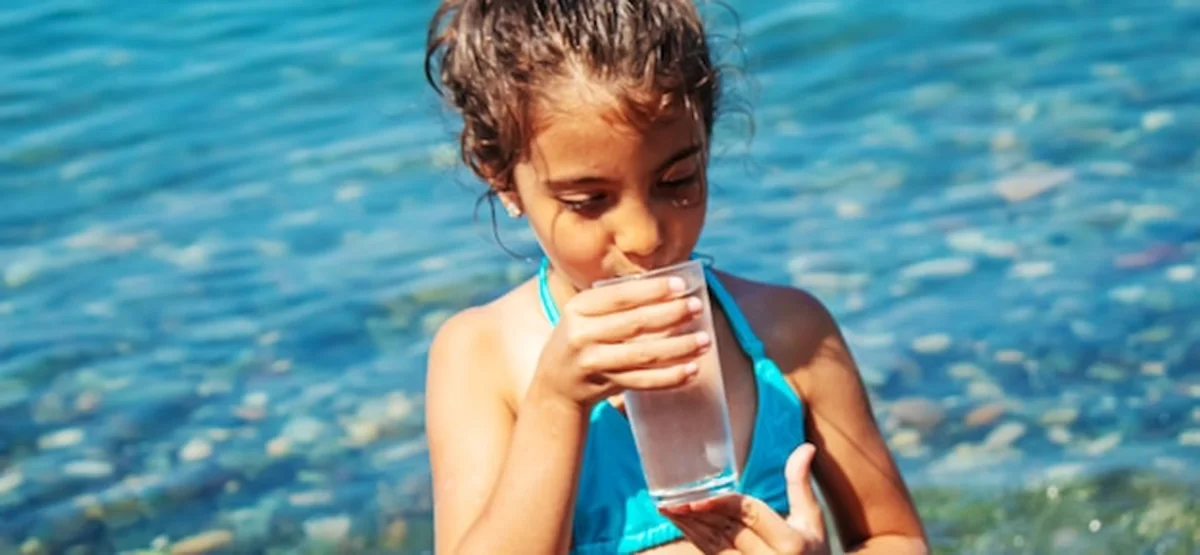 Dziecko pije wodę nad morzem