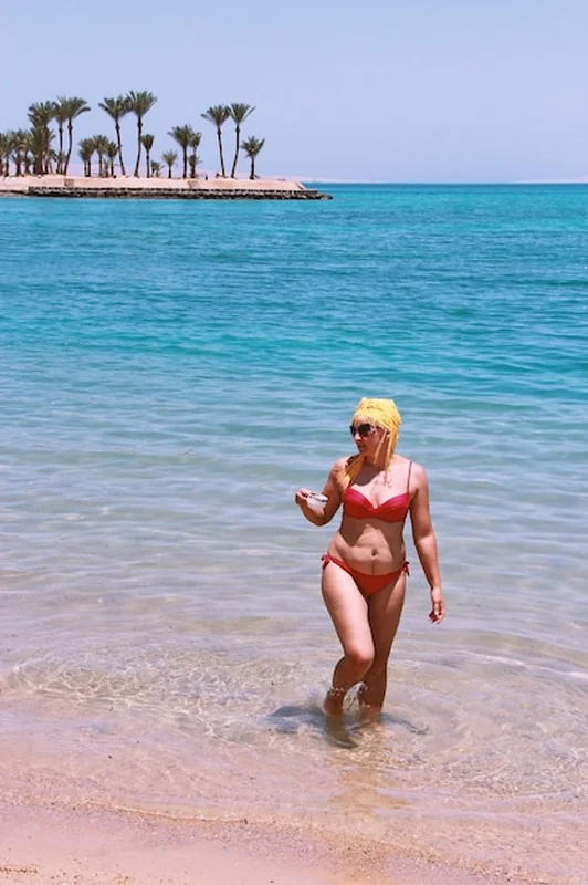 Kobieta pije kawę na plaży nad morzem