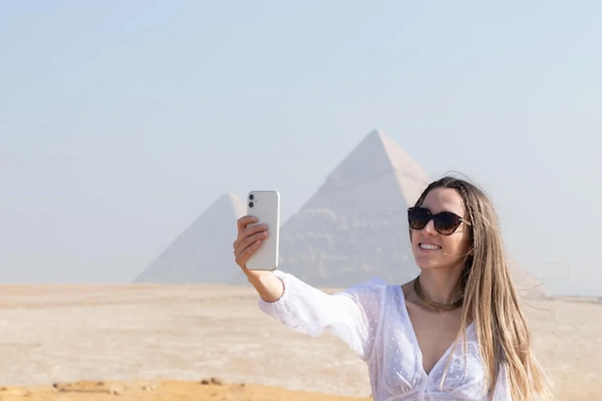 Młoda turystka robiąca selfie z piramidą w tle